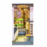 Book Nook Sakura Densya installé entre des livres sur une étagère, éclairage LED allumé